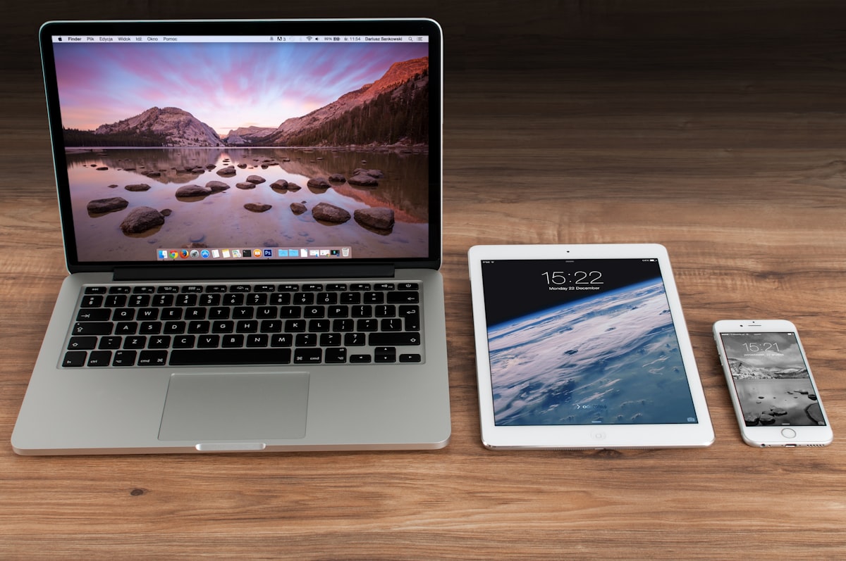 A MacBook, iPad and iPhone side by side, each showing a different screen size