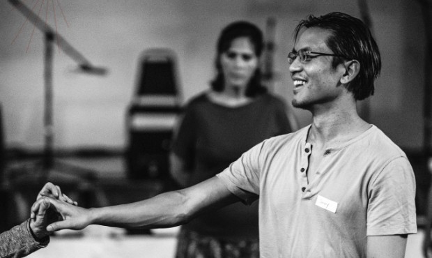 Black and white photo of a smiling man reaching out to shake hands, linking to the JohnnyVPS plans page